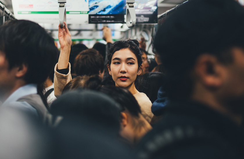 Focus on commuter holding hand strap on busy train