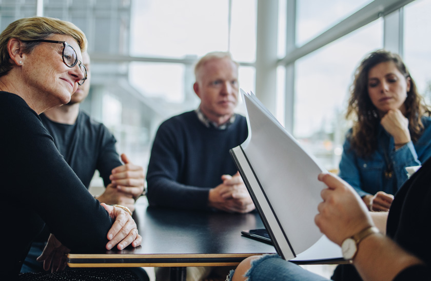 Team sat around a table in a meeting at work