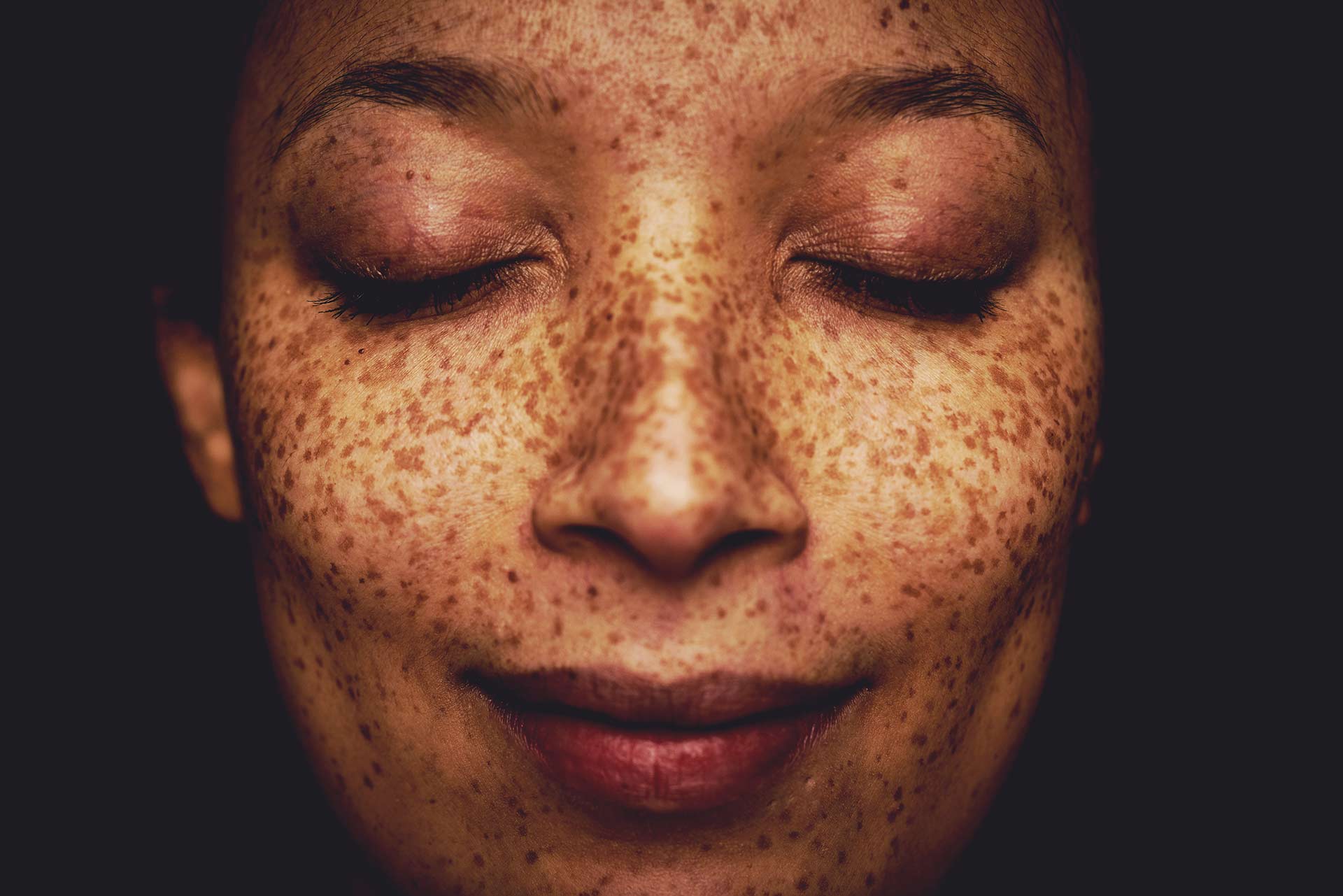 A close up of a woman's face, looking peaceful